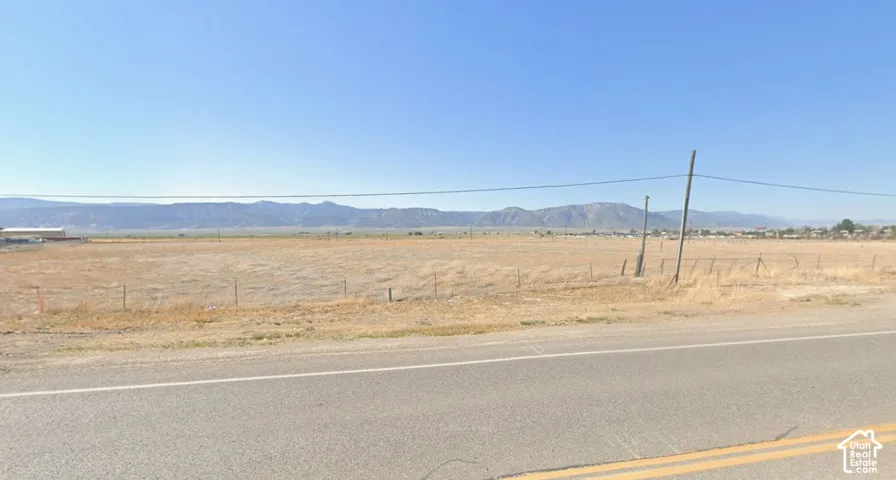 Expansive lot featuring a clear, open landscape with distant mountain ranges
