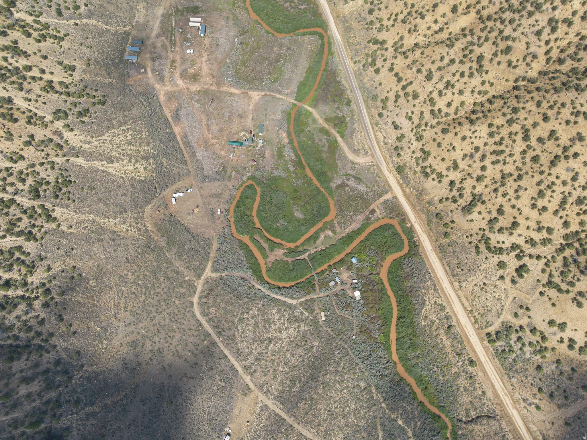 Aerial View. Presenting an overhead perspective of the property with a visible water feature and surrounding terrain