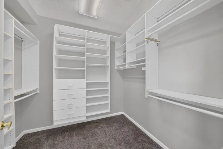 Built-in closet system with multiple shelves, hanging rods, and integrated drawers