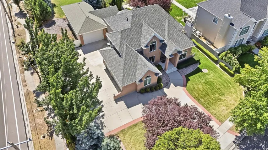 Brick exterior, multiple gabled rooflines, attached two-car garage, mature landscaping, and an expansive driveway