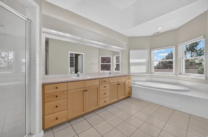 Expansive vanity with dual sinks, a large mirror, and ample storage cabinetry
