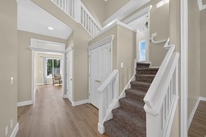 Vaulted ceiling entryway with wood-finish flooring