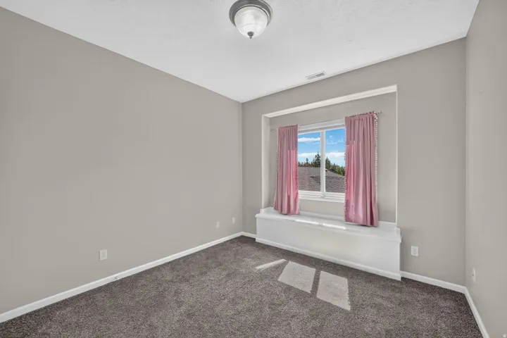 Built-in window bench, carpeted flooring, and a flush mount ceiling light fixture