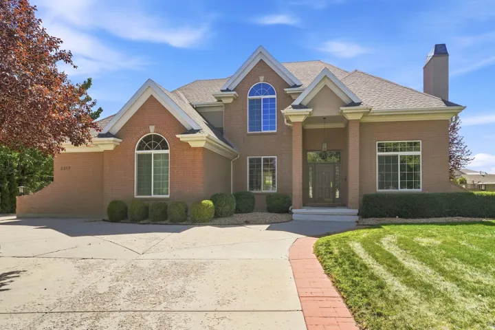 Brick exterior with multiple gables, arched windows, and an integrated chimney