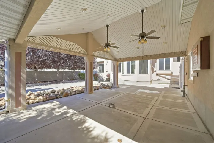 Spacious covered patio with concrete flooring, recessed lighting, and dual ceiling fans