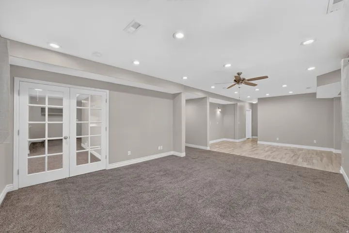 Recessed lighting throughout, french doors, ceiling fan, carpeted flooring, and wood-finish flooring