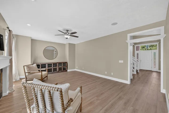 Recessed lighting, wood-finish flooring, ceiling fan, and white trim details