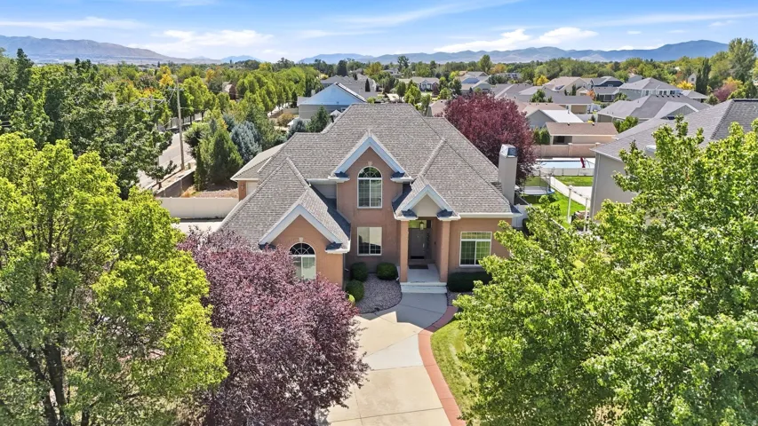 Traditional two-story residence with a multi-gable roof, a brick façade, and a paved circular driveway