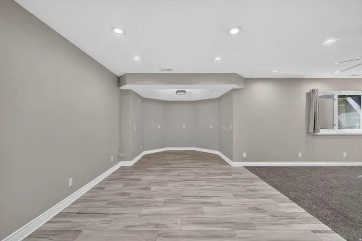 Recessed lighting, wood-finish flooring, and a curved architectural niche
