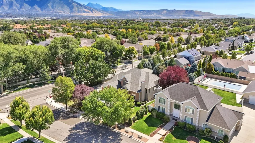 Residential neighborhood with mature trees and mountain scenery