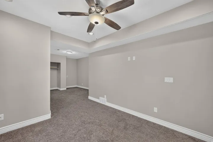 Tray ceiling with recessed lighting, ceiling fan with light fixture, wall-to-wall carpeting, and neutral wall tones