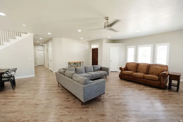 Open-concept living area featuring wood-finish flooring, recessed lighting, and a contemporary ceiling fan