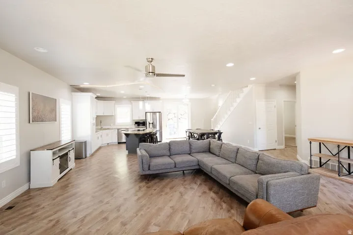 Open-concept living area featuring wood-finish flooring, recessed lighting, and a ceiling fan