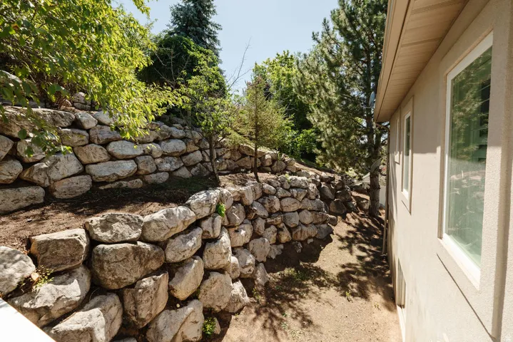 Stone retaining walls with surrounding natural landscaping and mature trees