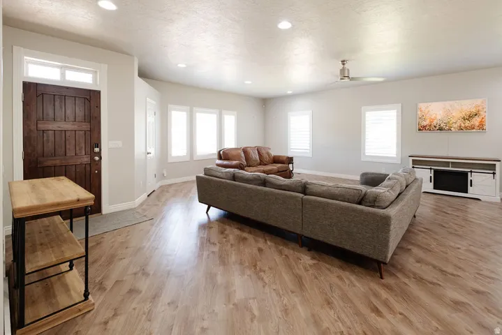 Wood-finish flooring throughout, recessed lighting, ceiling fan, and white window shutters