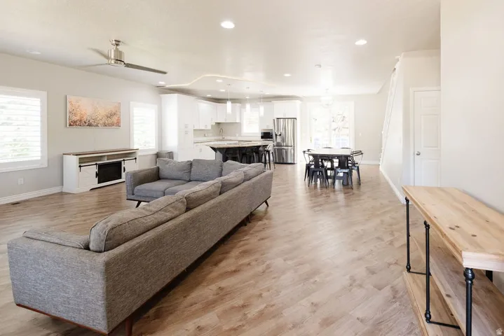 Open-concept living space featuring wood-finish flooring, recessed lighting, and a ceiling fan