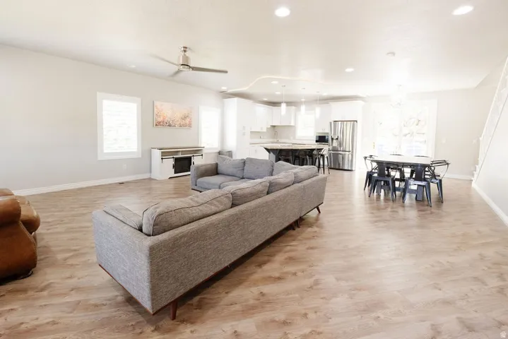 Open-concept living space featuring wood-finish flooring throughout, recessed ceiling lighting, and ceiling fans