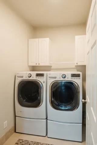 White shaker cabinetry, ceramic tile flooring, and a paneled door