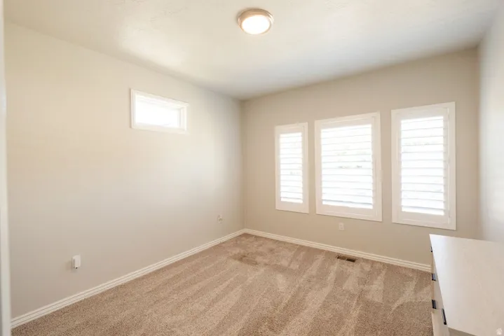 Neutral-toned walls complement plush carpeting
