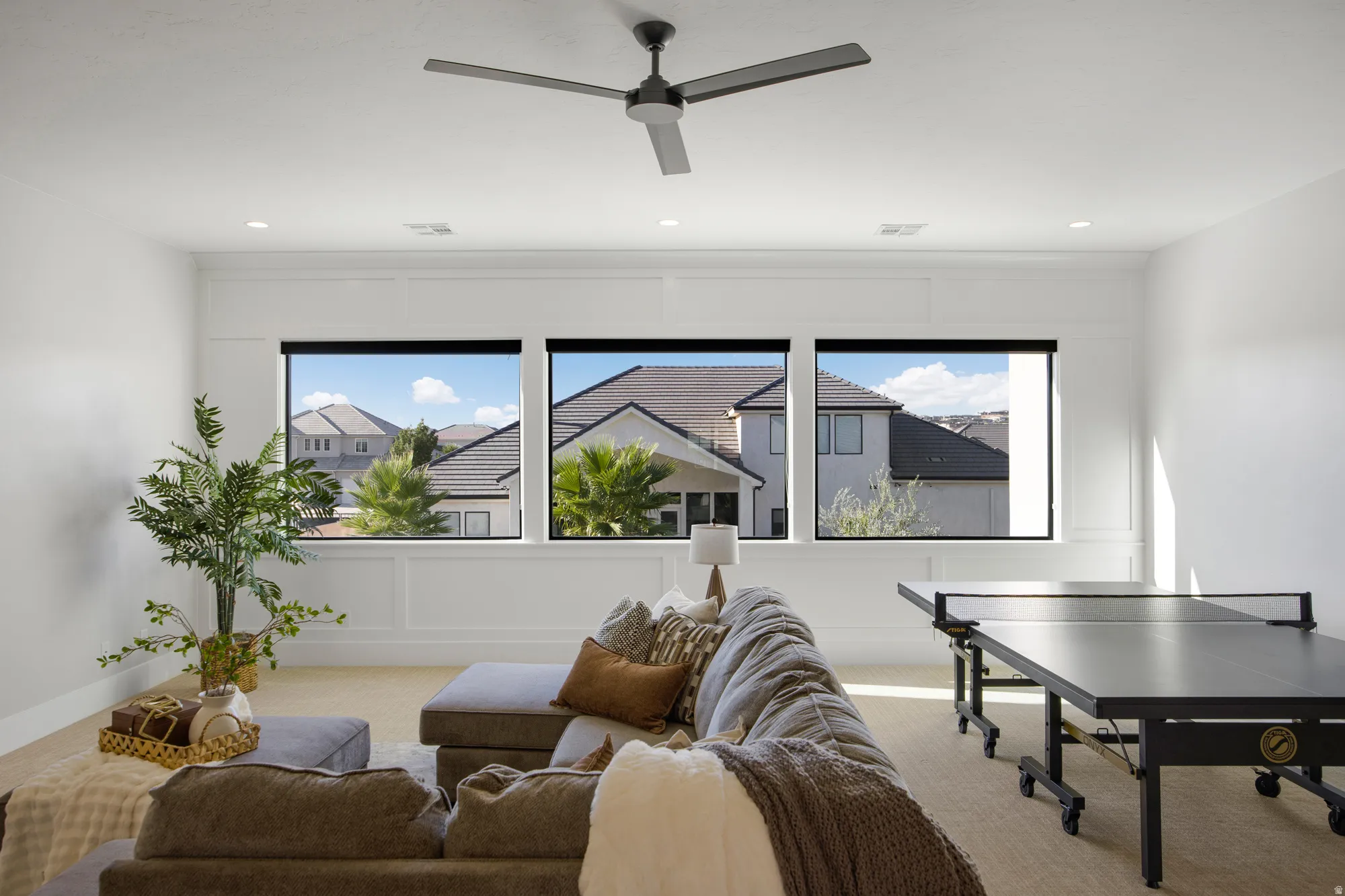 Recessed lighting, ceiling fan, three horizontal windows, and decorative wall paneling
