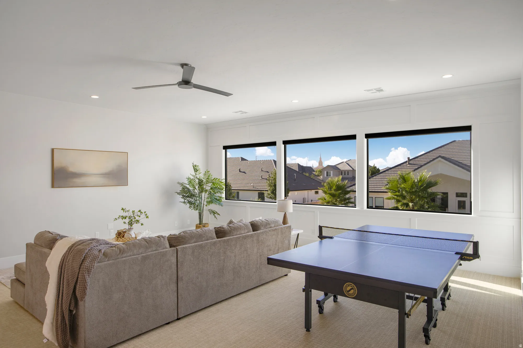 Spacious room with multiple windows, recessed lighting, a ceiling fan, and paneling detailing on walls