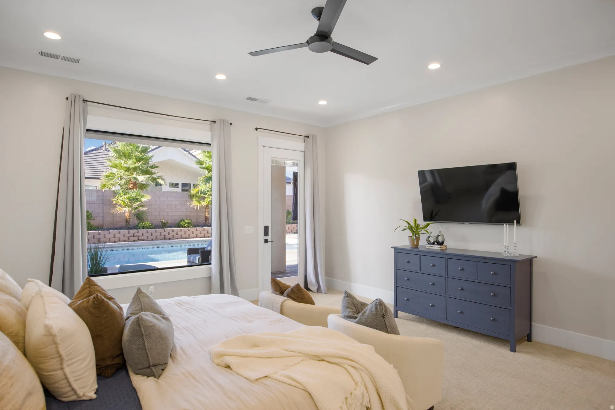 Recessed lighting illuminates the room, complemented by a ceiling fan