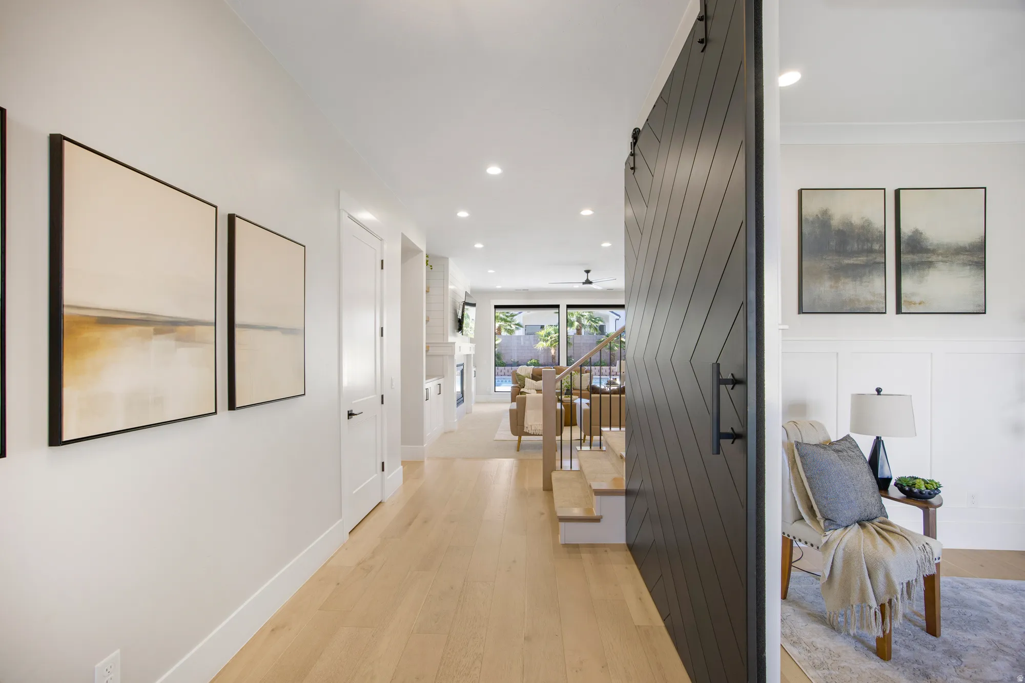 Light wood-finish flooring throughout, recessed lighting, and white interior doors