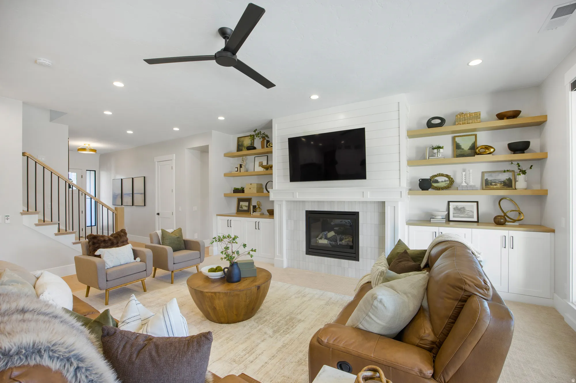 Living area with a fireplace, shiplap accent wall, built-in cabinetry, floating shelves, and recessed lighting