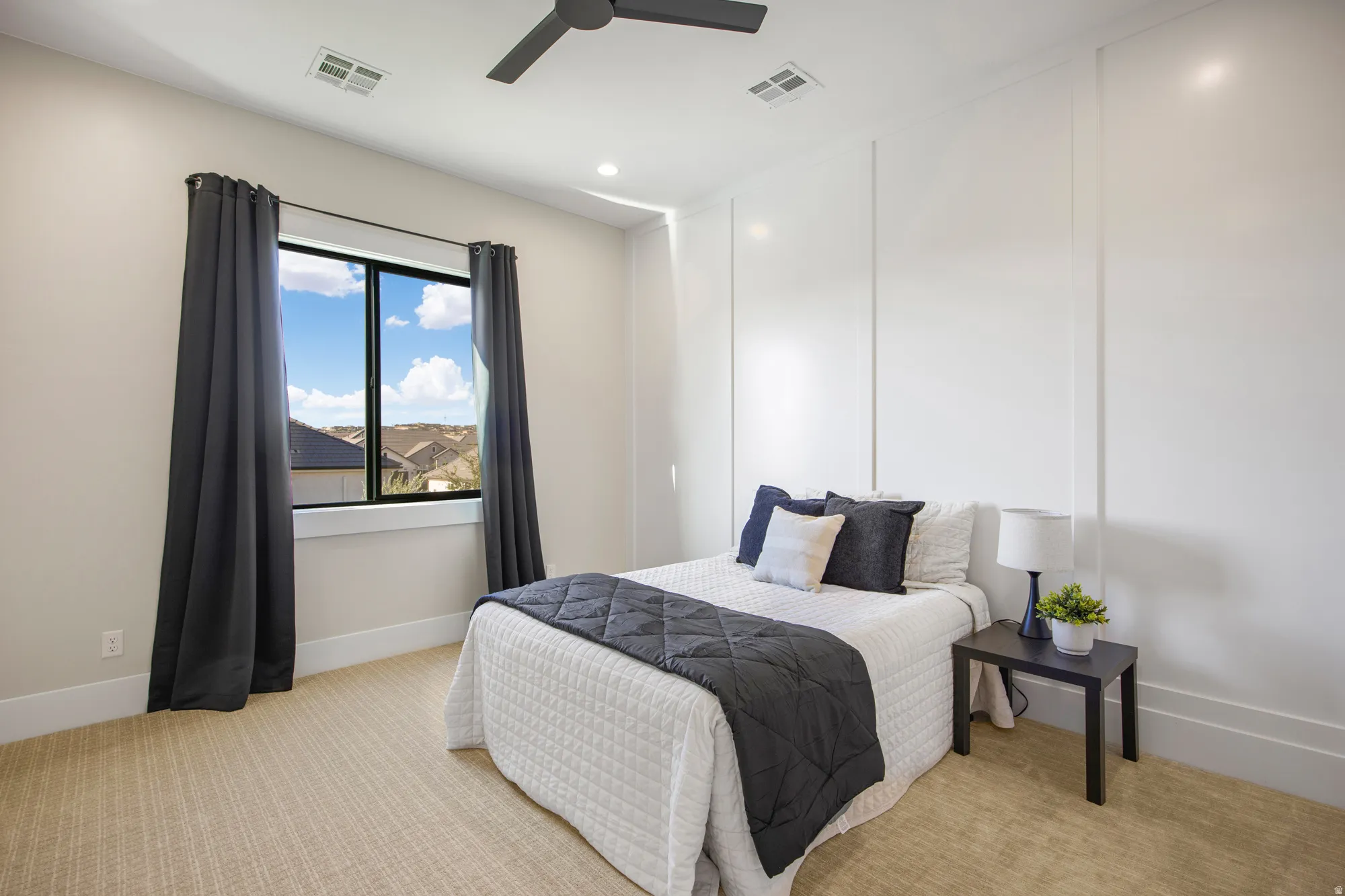 Accent wall with vertical paneling, recessed lighting, ceiling fan, large window, and textured carpeting