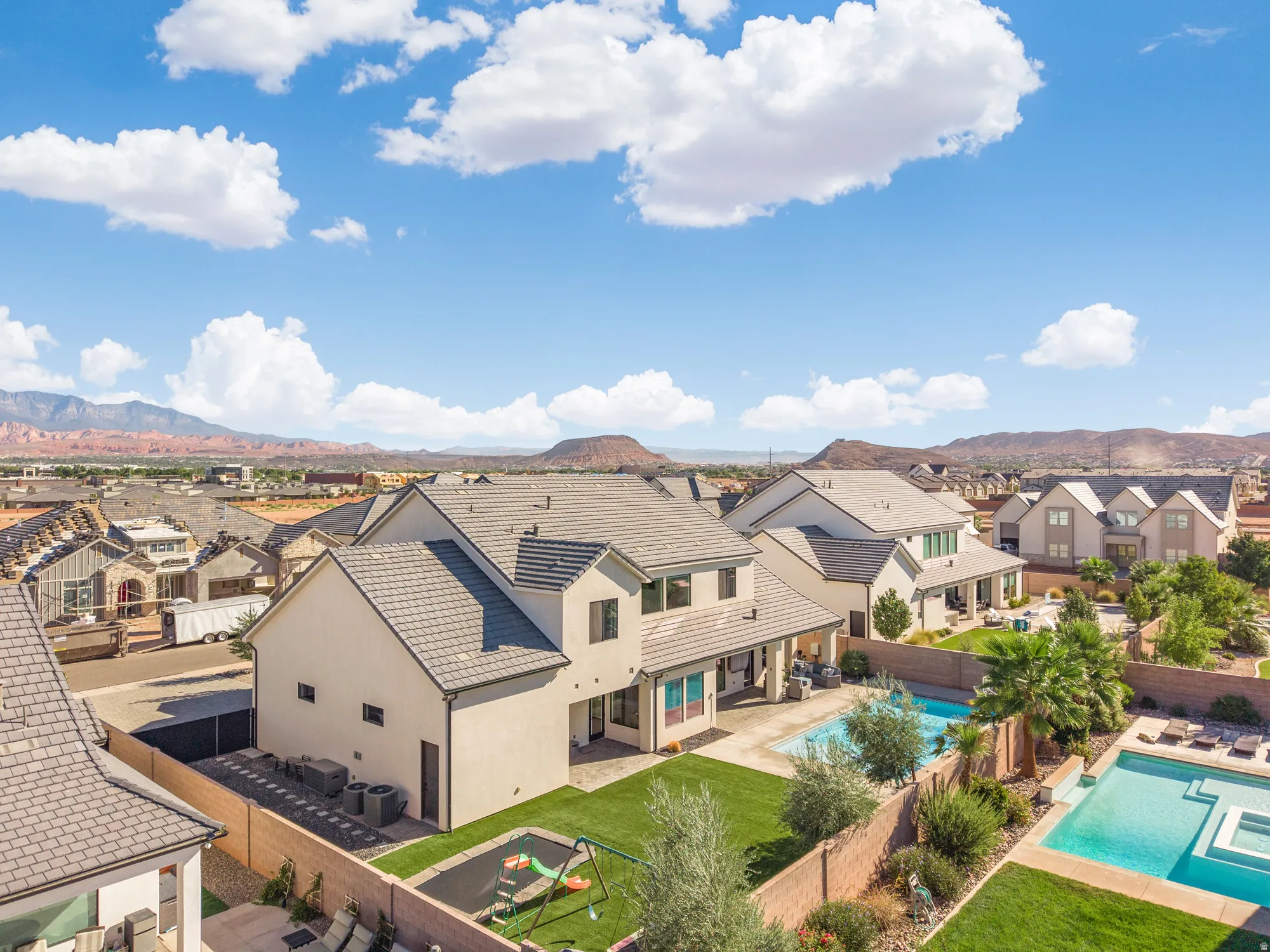 Residential property with a multi-level exterior, concrete tile roof, and a private swimming pool
