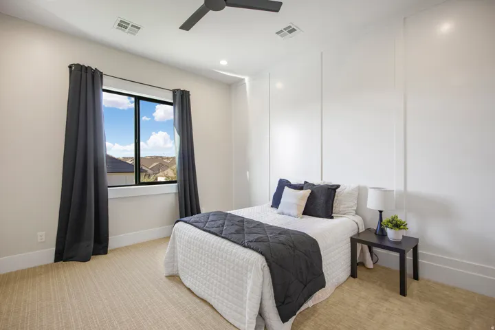 Accent wall with vertical paneling, recessed lighting, ceiling fan, large window, and textured carpeting