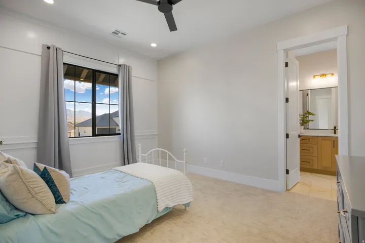 Plush carpeted flooring, a black ceiling fan, recessed lighting, and a window with black grilles
