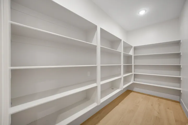 Wraparound built-in shelving, recessed ceiling lighting, and wood-finish flooring