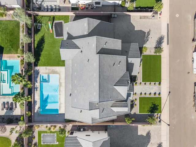 Pitched tile roof, private swimming pool, extensive paved patio, landscaped backyard with artificial turf, and a manicured front yard