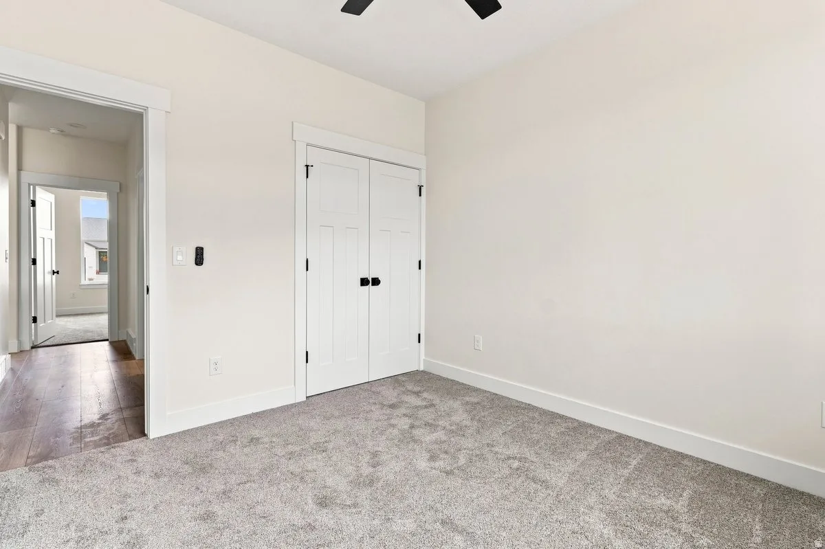 Plush carpeting, paneled closet doors with black hardware, recessed ceiling fan, and light wall finishes