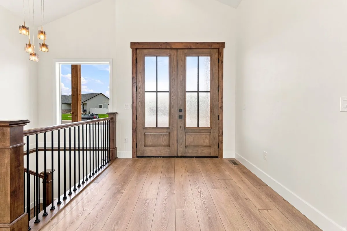 Wood-finish flooring, vaulted ceiling, and a contemporary multi-light fixture