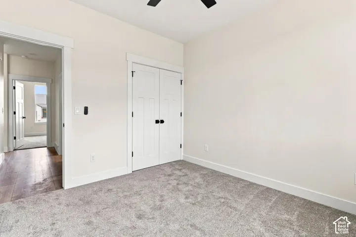 Plush carpeting, paneled closet doors with black hardware, recessed ceiling fan, and light wall finishes