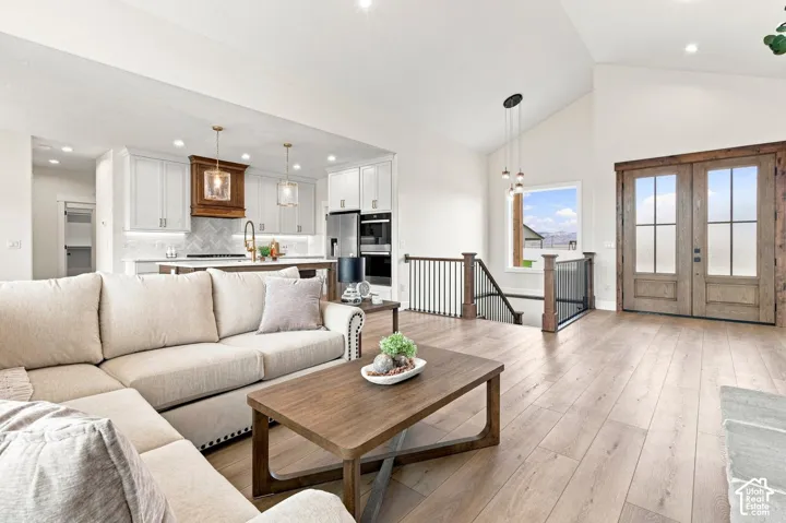 Vaulted ceilings, wood-finish flooring, and a modern kitchen with a chevron tile backsplash