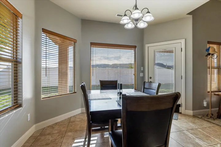 Recessed dining area with multiple windows, a ceiling-mounted light fixture, and tile flooring