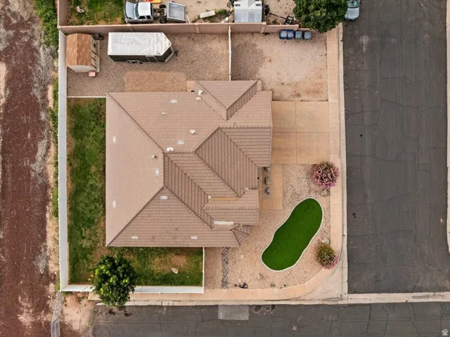 Pitched roofline, concrete driveway, gravel landscaping, artificial turf feature, and mature shrubs