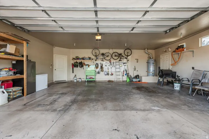Spacious garage with concrete flooring, overhead lighting, and multiple windows