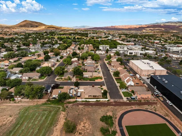 Expansive residential area featuring numerous single-family homes, mature tree-lined streets, and a distant mountain backdrop