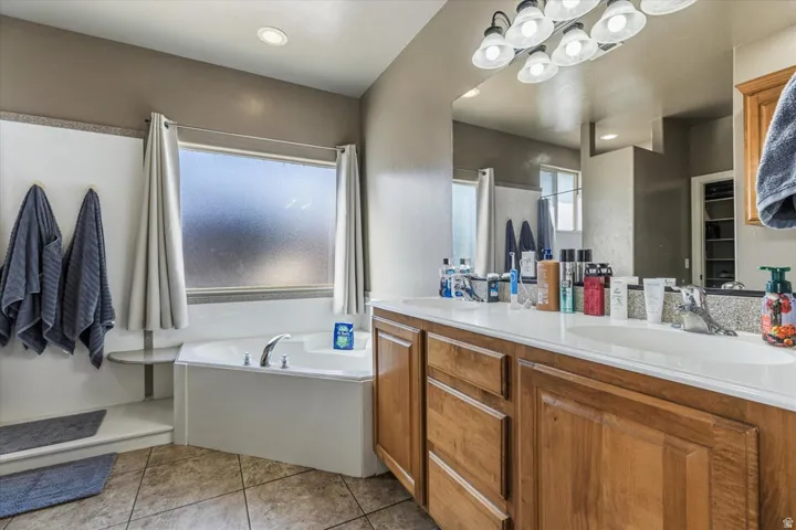Dual vanity with integrated sinks, wood-finish cabinetry, and overhead lighting