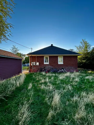 Brick exterior with white-framed windows and a dark shingle roof