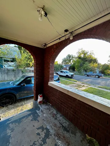 Brick archway entry with a concrete porch