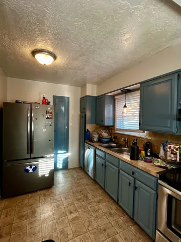 Kitchen featuring blue cabinetry, a stainless steel refrigerator