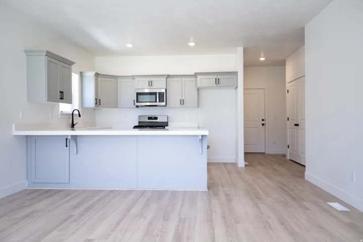 Kitchen with large peninsula and quartz counters