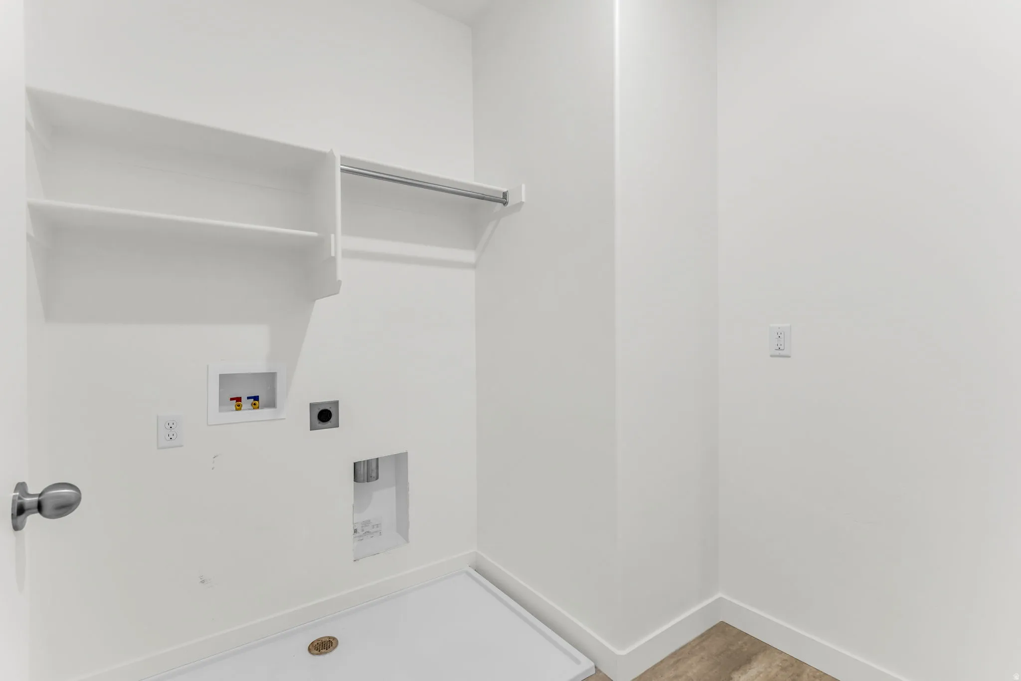 Laundry area with built-in shelving, hanging rod, and utility hookups