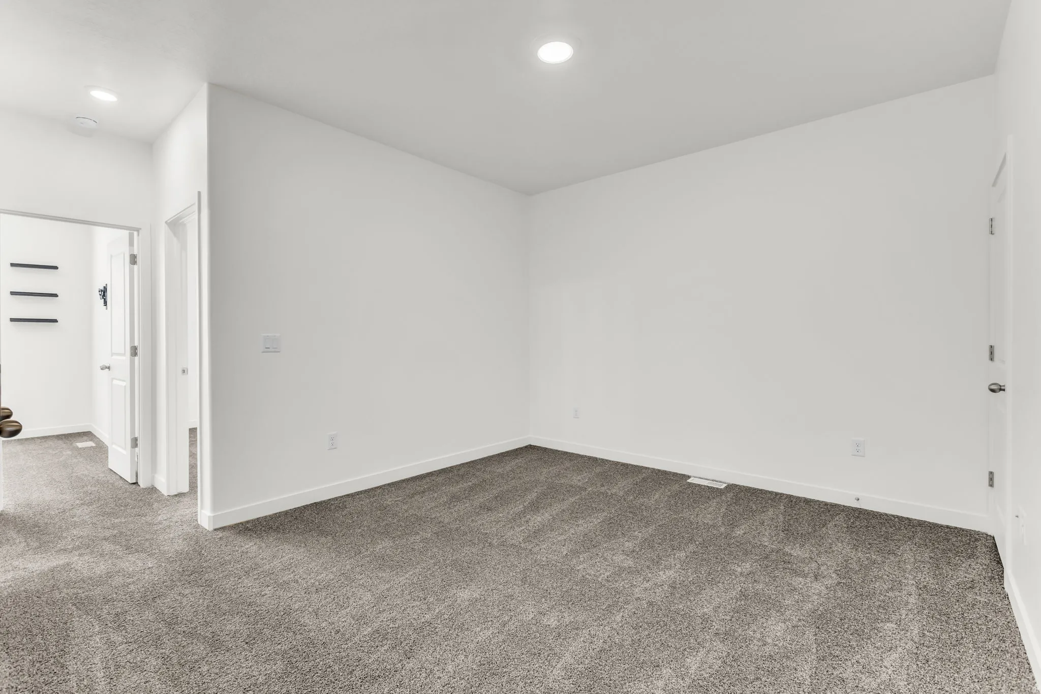 Recessed lighting, neutral wall paint, and gray carpet flooring