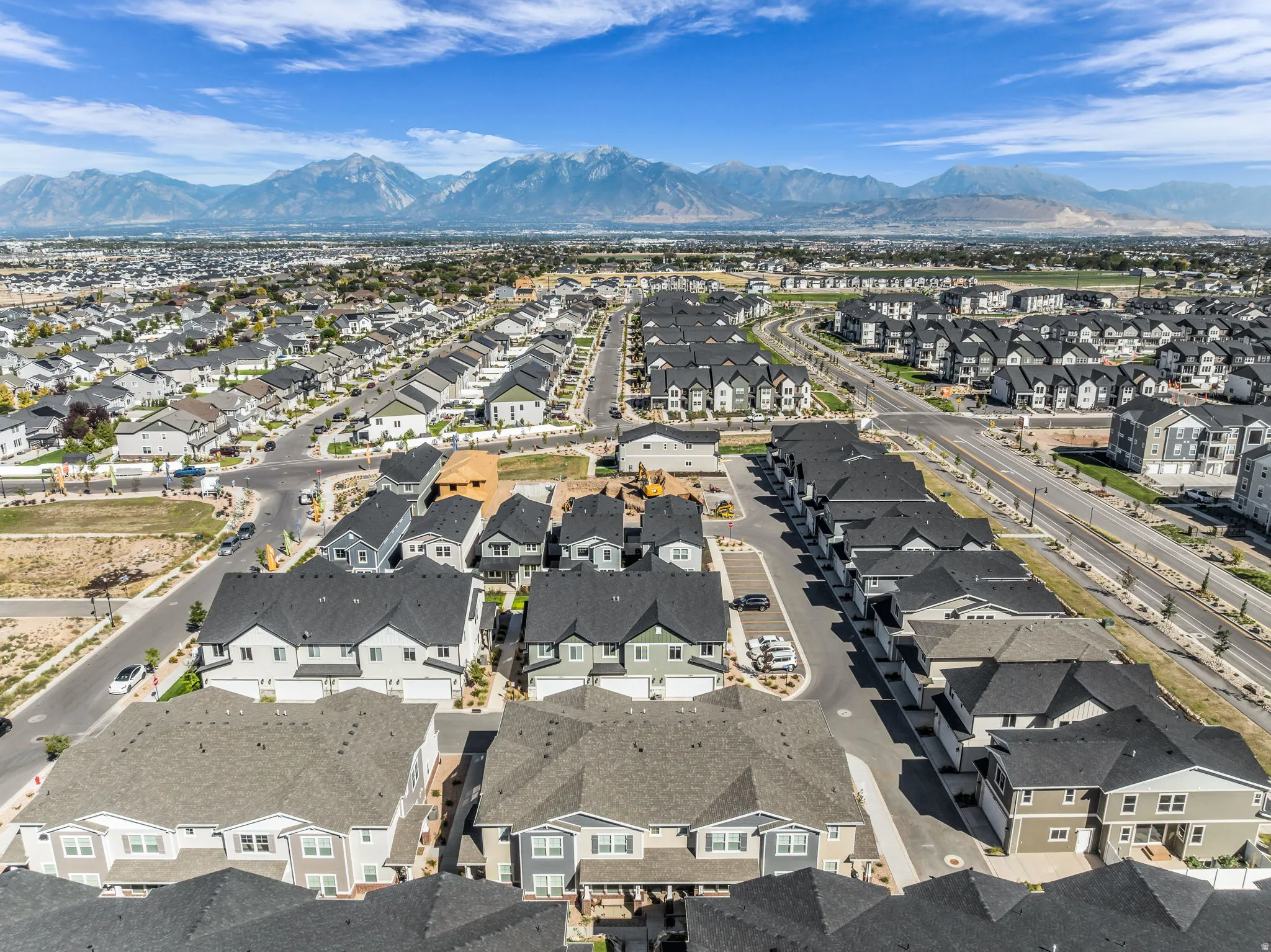 Residential neighborhood featuring a variety of housing styles, paved roadways, and mountain backdrop